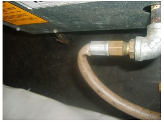 Photo of a damaged gas hose on a temporary cooking setup at an outside event
