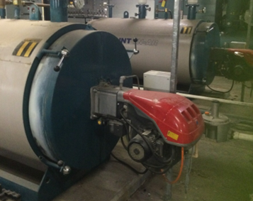 Photo of a large silver boiler with a red section at the front of it. There is a second similar looking boiler behind it.