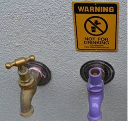 Figure W 9: example of a non-drinking water signage. Its a yellow and black sign with 'Warning' at the top and says 'Not for drinking'.